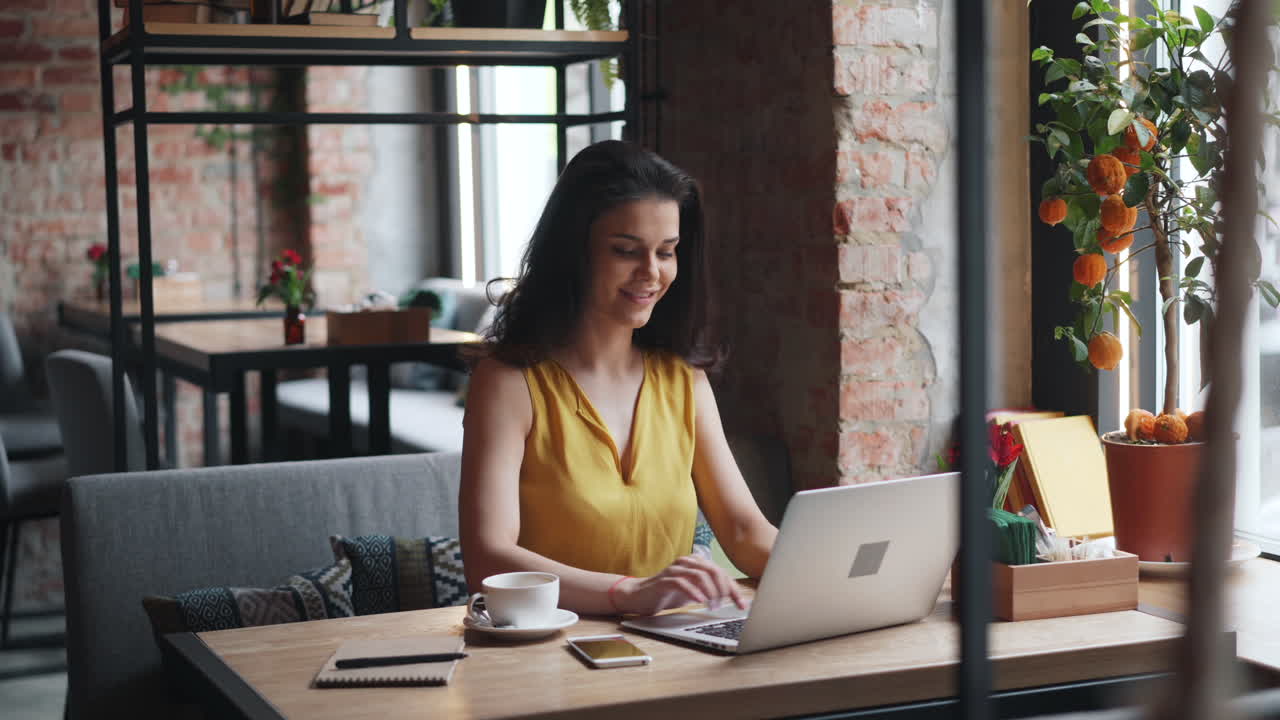 mujer trabajando en una computadora portátil en un café