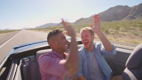 Two-Male-Friends-On-Road-Trip-In-Convertible-Car-Shot-On-R3D