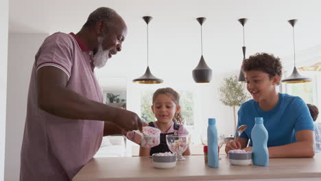 Abuelo-Sirviendo-Helado-A-Sus-Nietos-En-La-Cocina