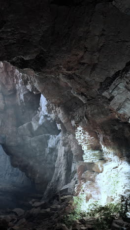 a dark and mysterious cave entrance with light shining in