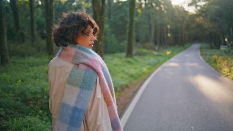 stylish traveler walking forest path at sunlight. lady wanderer enjoy journey