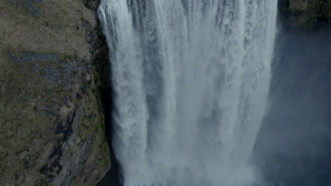 Tiro-Aéreo-Descendente-Lento-Sobre-La-Poderosa-Cascada-Skógafoss-Islandia