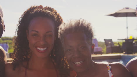 Multi-Generation-Family-With-Adult-Offspring-On-Summer-Holiday-Relaxing-In-Swimming-Pool-Together