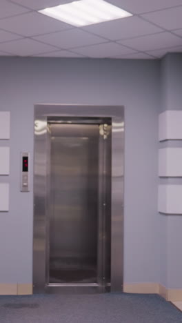 professional woman walking down office corridor, carrying red folder and heading toward elevator in modern business building. clean, minimalist design ideal for corporate, business, or office use
