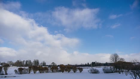 winter countryside timelapse with falling snow and fast-moving clouds over snowy landscape. day to night timelapse. full day timelapse