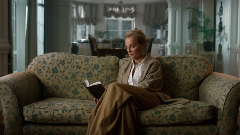 Old-aged-woman-reading-book-in-luxury-living-room