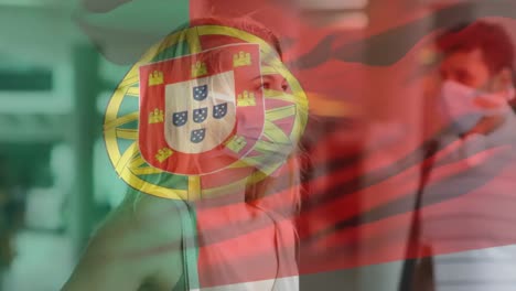 animation of flag of portugal waving over woman wearing face mask during covid 19 pandemic