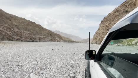 Pov-Fuera-De-La-Ventana-De-Suv-Conduciendo-A-Lo-Largo-Del-Paisaje-Rocoso-Del-Desierto-En-Khuzdar,-Baluchistán
