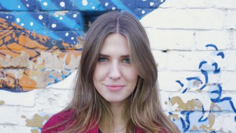 woman smiling in front of a mural