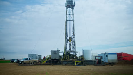 a metal tower for oil production. high support with the necessary drilling equipment on the ground beside.