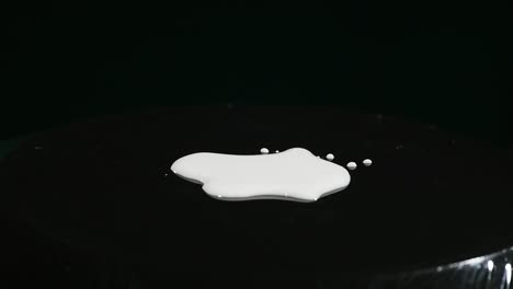 milk on moving subwoofer on black background