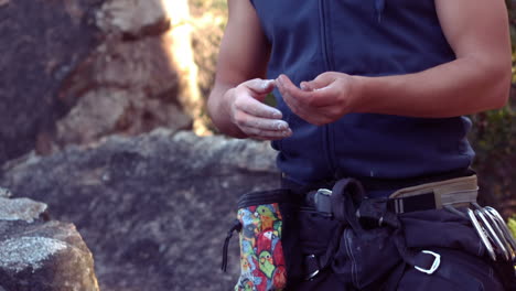 hombre tiza sus manos para la escalada en roca