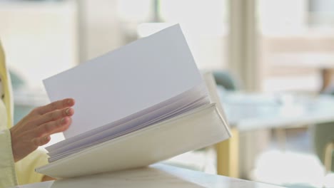 a woman siting on a table in the living room with her book and drink, close up shot, push in shot