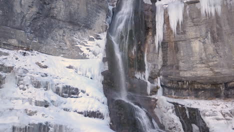 a winter waterfall high in the mountains with beautiful icicles hanging at the sides