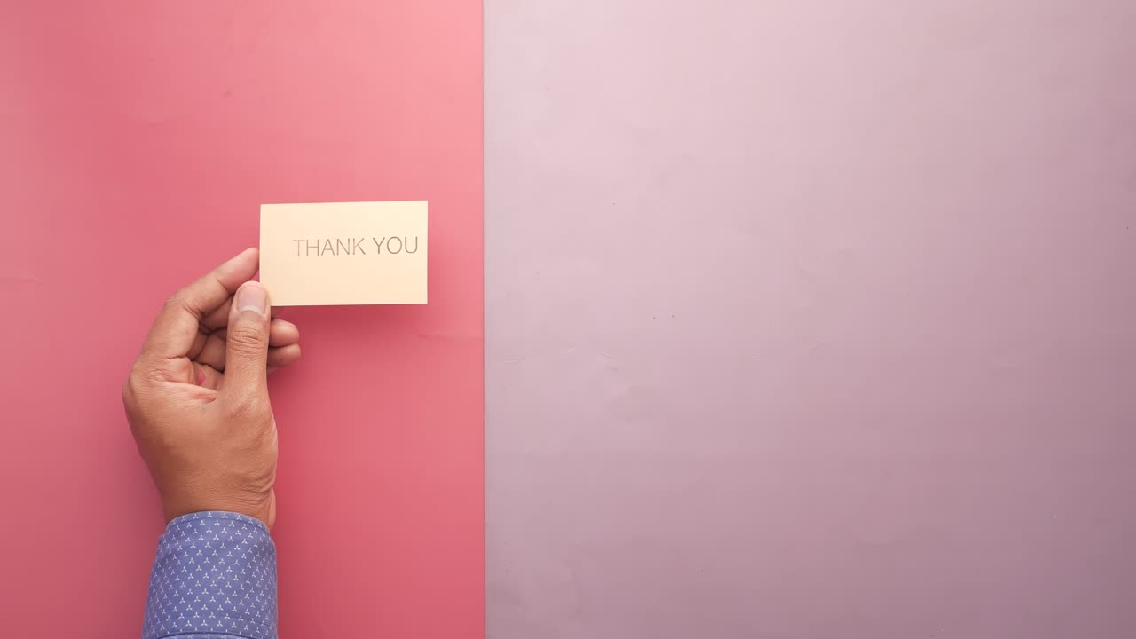 손은 분홍색과 보라색 배경에 감사 편지를 들고 있습니다.