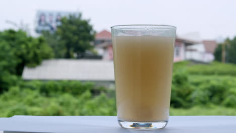 jugo de piña frente a la terraza de la ventana