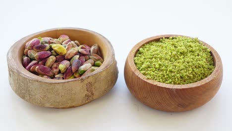 pistachios and pistachio powder in wooden bowls