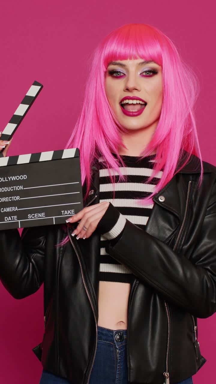 Vertical video: Glamour carefree woman holding film slate and saying action