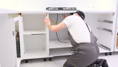 a man collects kitchen furniture repair of the kitchen using a construction laser