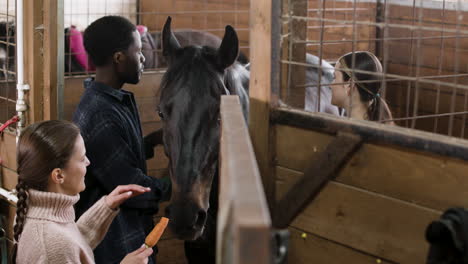 un hombre y una niña acariciando un caballo