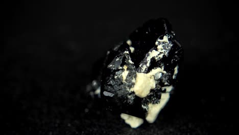 seamlessly rotating a black mineral (tourmaline) in front of black background