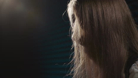 girl face closed with loose hair stands in musical academy closeup. attentive little girl with hair flowing freely engages in performance of musical art. artistic hobby