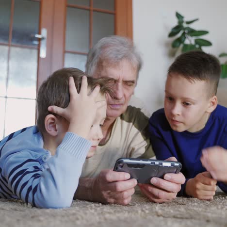 senior and children holding mobile phone