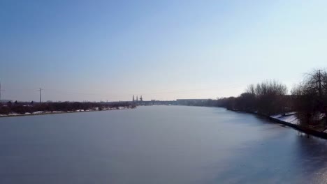 Flying-forward-above-a-frozen-lake-in-a-park-in-Romania,-Bucharest