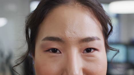 portrait of asian businesswoman looking at camera in office, slow motion