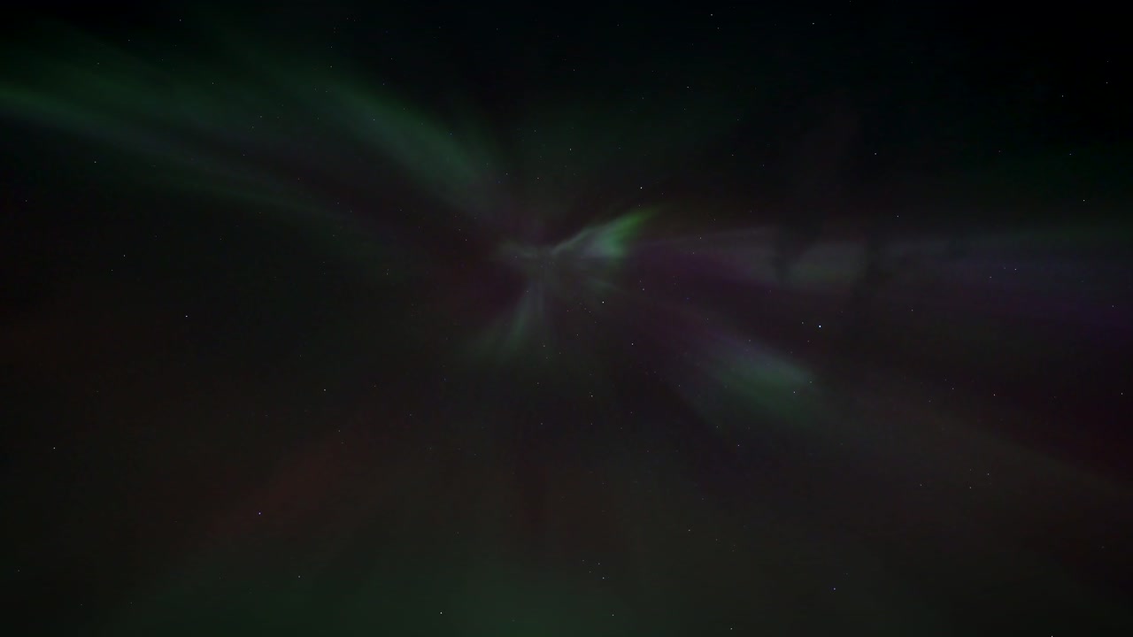 Flickering lights at night sky of aurora borealis. Purple and green lights at dark sky. Bottom up. Icelandic trip in Europe.