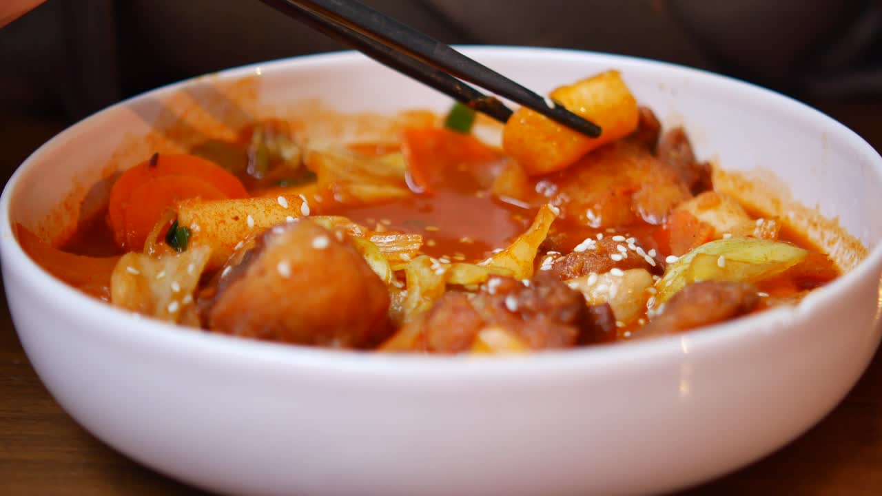 Tampilan Dekat Tteokbokki Pedas Korea yang Dimakan dengan Sumpit