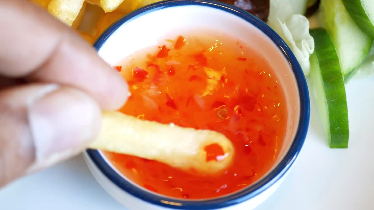Fries dipped in sweet chili sauce