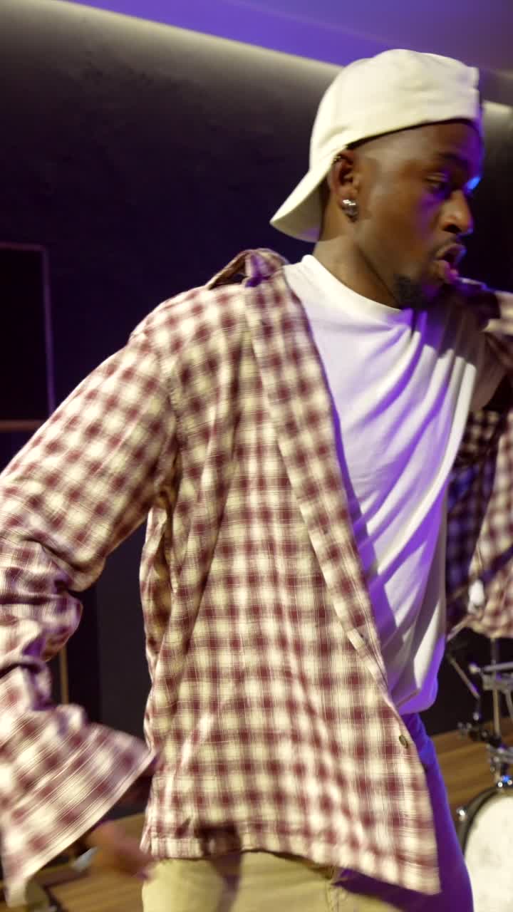 Uomo con camicia a quadri che suona in uno studio