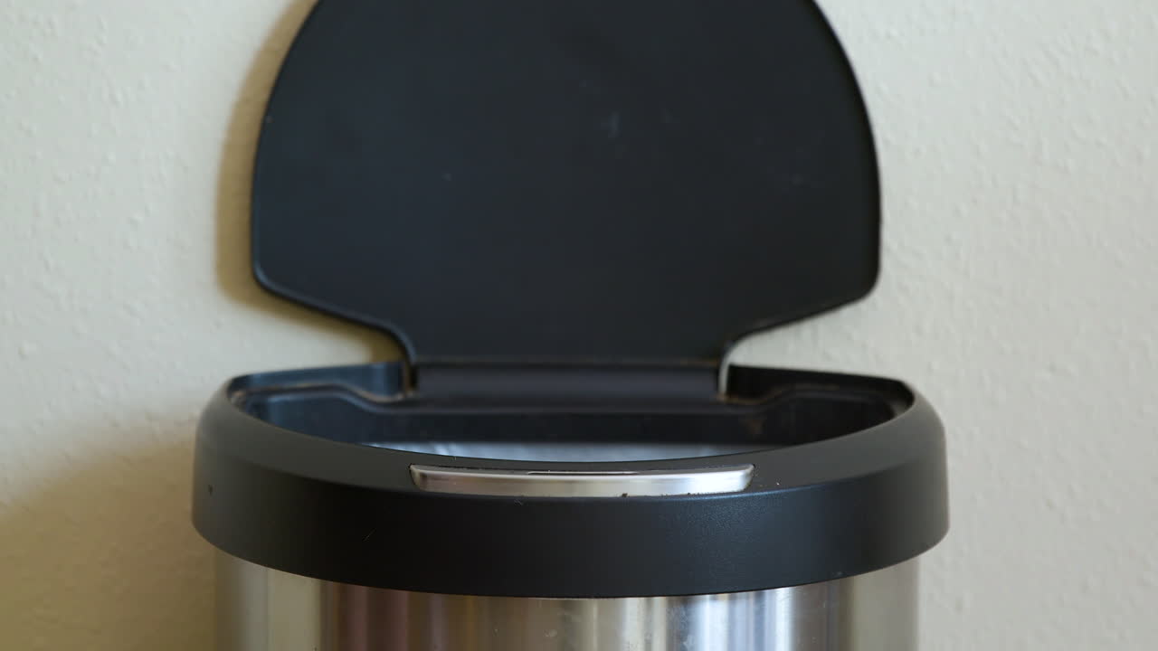 Uomo getta una buccia di banana in un cestino automatico senza contatto con sensore di movimento - Primo piano