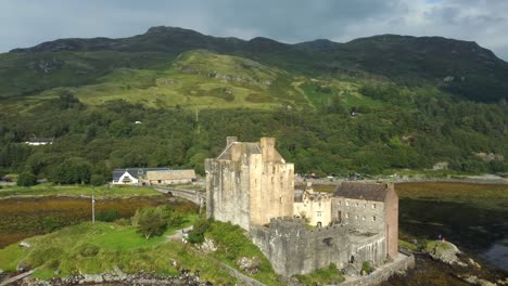 Castillo-De-Eilean-Donan-En-Las-Tierras-Altas-De-Escocia,-Reino-Unido-_-Drone-Disparó-La-Puesta-De-Sol-Con-Un-Hermoso-Lago