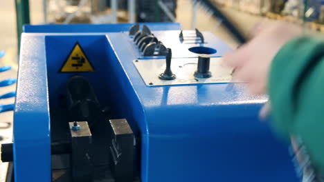 worker squeezing rubber hose with iron tip on machine. rubber hose processing