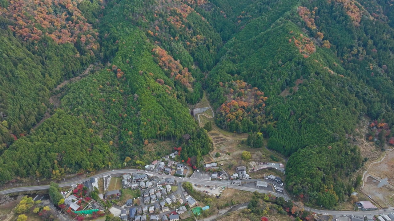 Aerial fly Valley and road between Autumn Colorful Mountains of Kyoto Japan, city with Fall colors, Yase Neighborhood