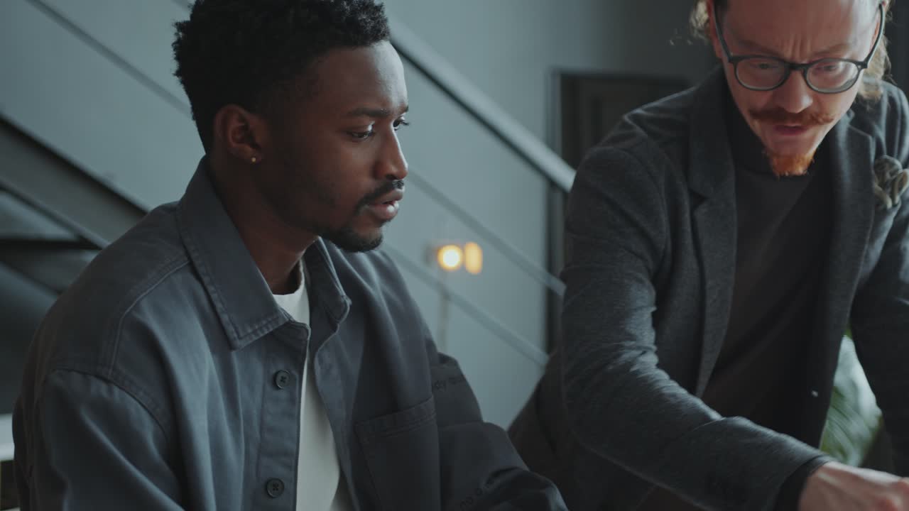 Manager Explaining Business Plan on Laptop to Colleague in Office