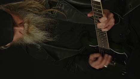 vertical format: hip man with beard plays green sg electric guitar
