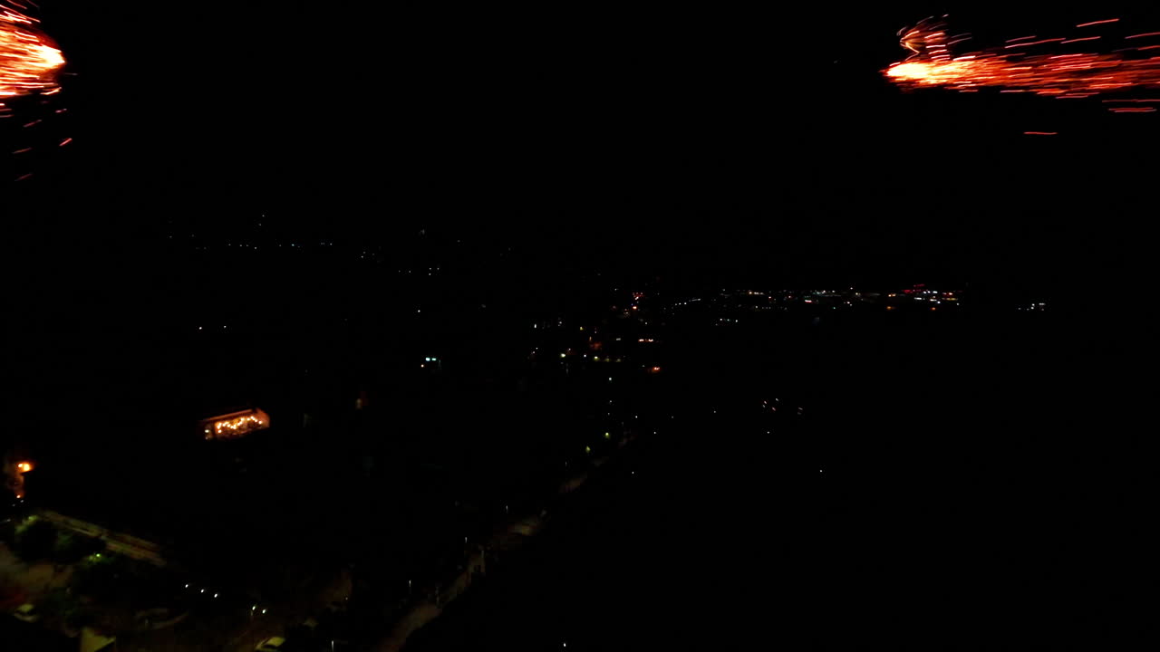 Slow motion fireworks flying over city at night, festive and vibrant