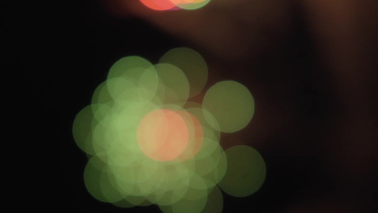 Sfondo bokeh di scintille di fuochi d'artificio che esplodono nel cielo.