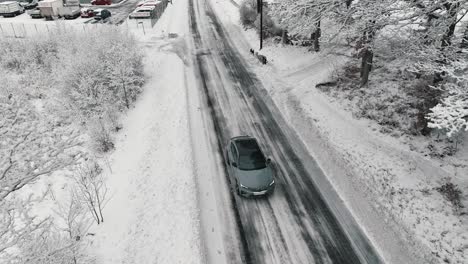 Drone-footage-of-car-driving-in-the-winter-forest-road