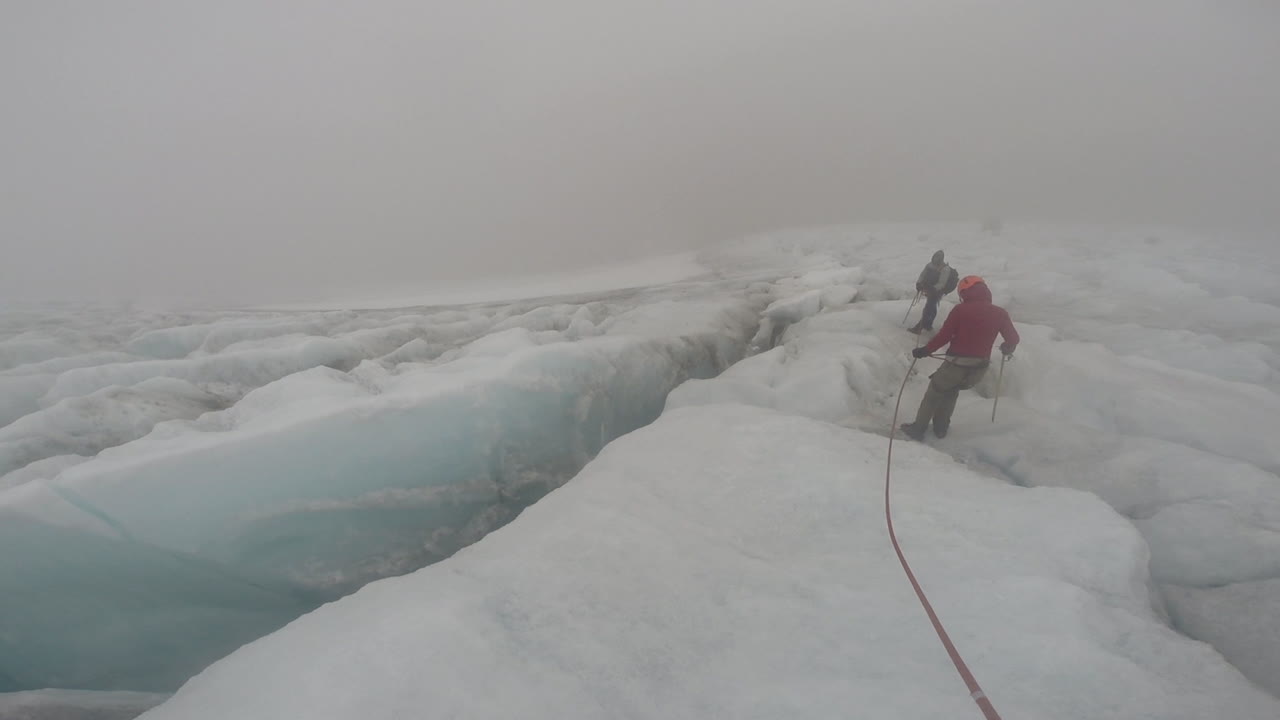 Mountain track team going around big crack (silt) on ice in Cocuy