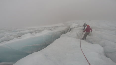 mountain track team going around big crack (silt) on ice in cocuy