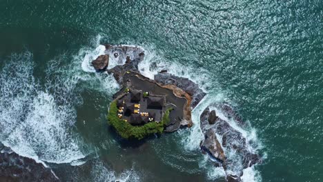 bird's eye view over tanah lot temple in the sea in bali, indonesia - drone shot