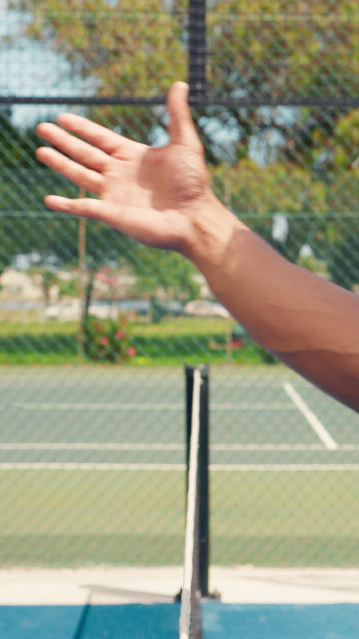 Close-up of Two Hands Performing a Fist Bump on a Tennis Court