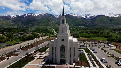 flying around layton temple starting at front moving forward and off to right seeing full side as well as beautiful wasatch mountains and blue sky