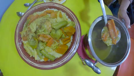 moroccan woman is serving traditional moroccan couscous