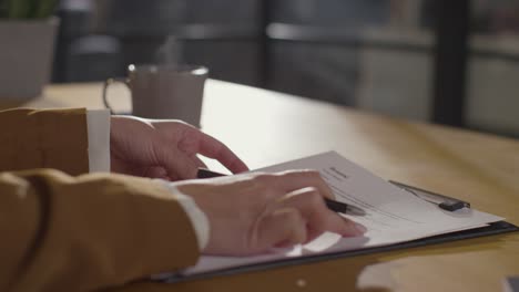 close up of businesswoman in office reviewing and making notes on application or cv for job vacancy 1