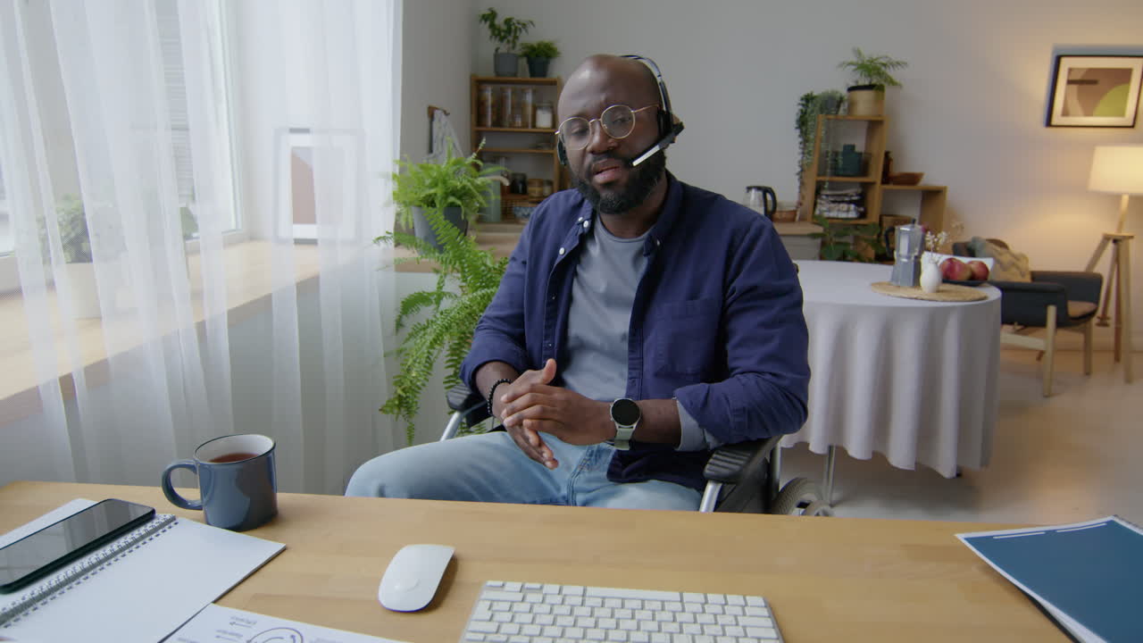 Black Man in Wheelchair Talking on Web Call with Headset